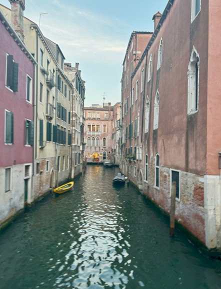 A boat filled canal running between two older looking buildings